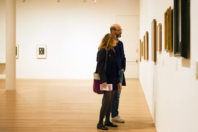 Foto von zwei Personen, welche sich ein Bild in der Ausstellung ansehen