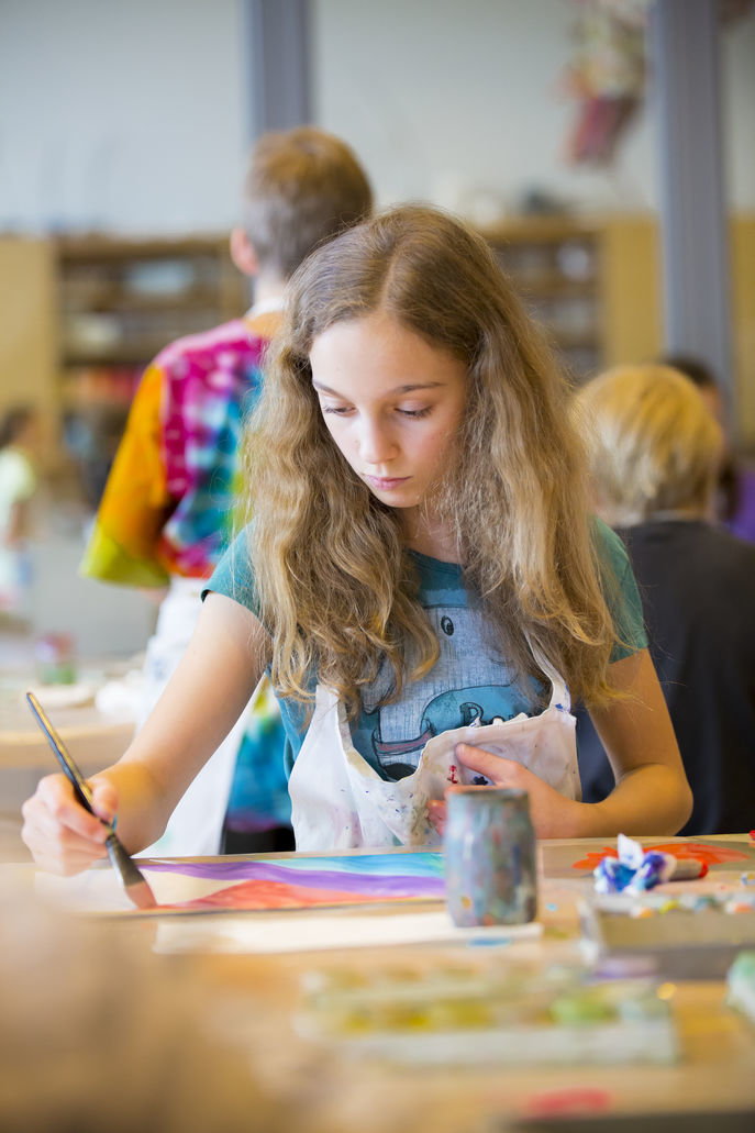 Ein Mädchen malt ein Bild in einem Atelier