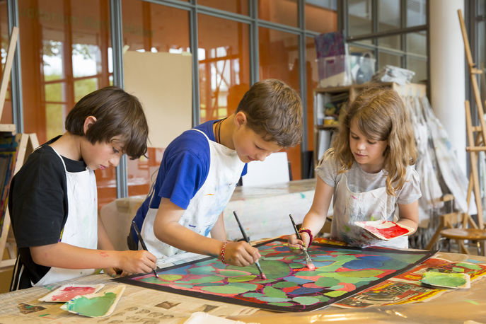 Drei Kinder malen gemeinsam ein Bild